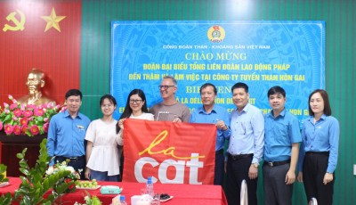 Đồng chí Gérard Ré tặng cờ của Liên đoàn lao động Pháp và cùng chụp ảnh lưu niệm 